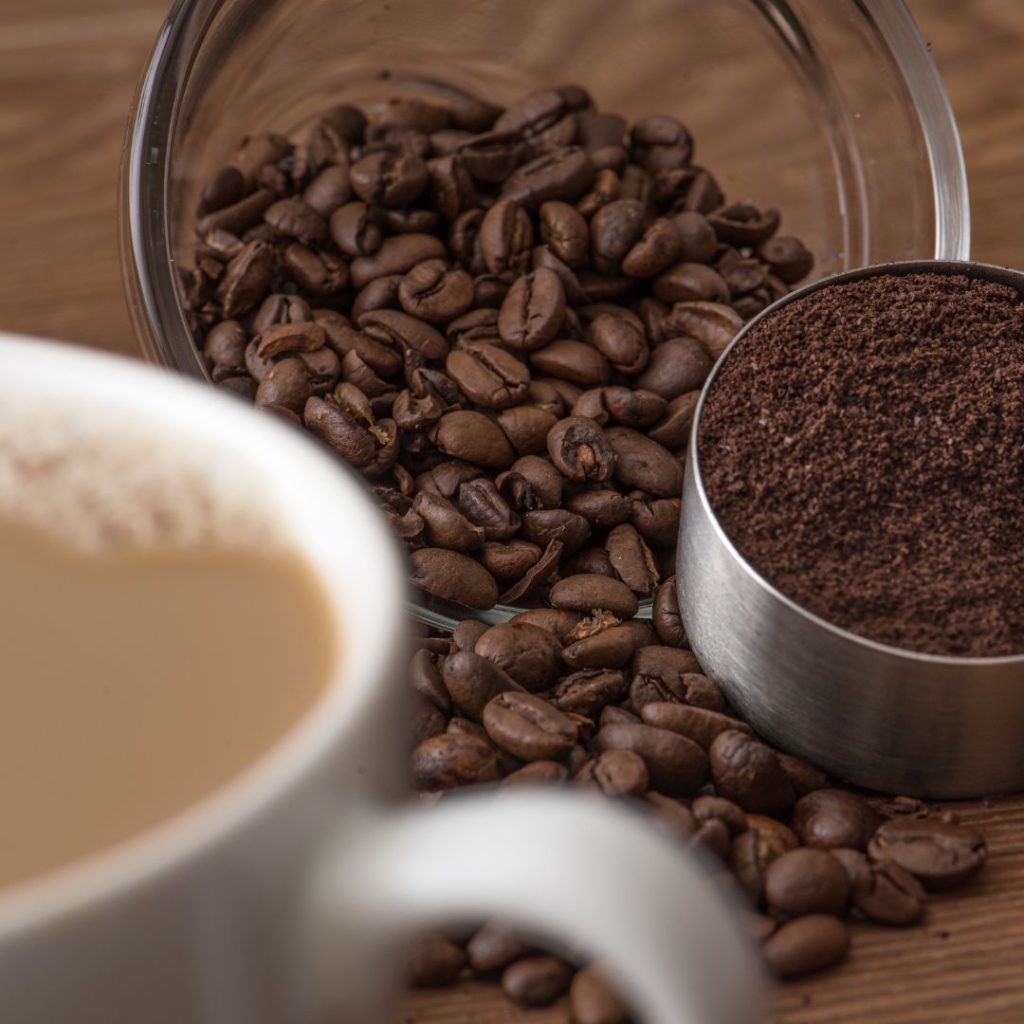 A cup of coffee and beans on a table