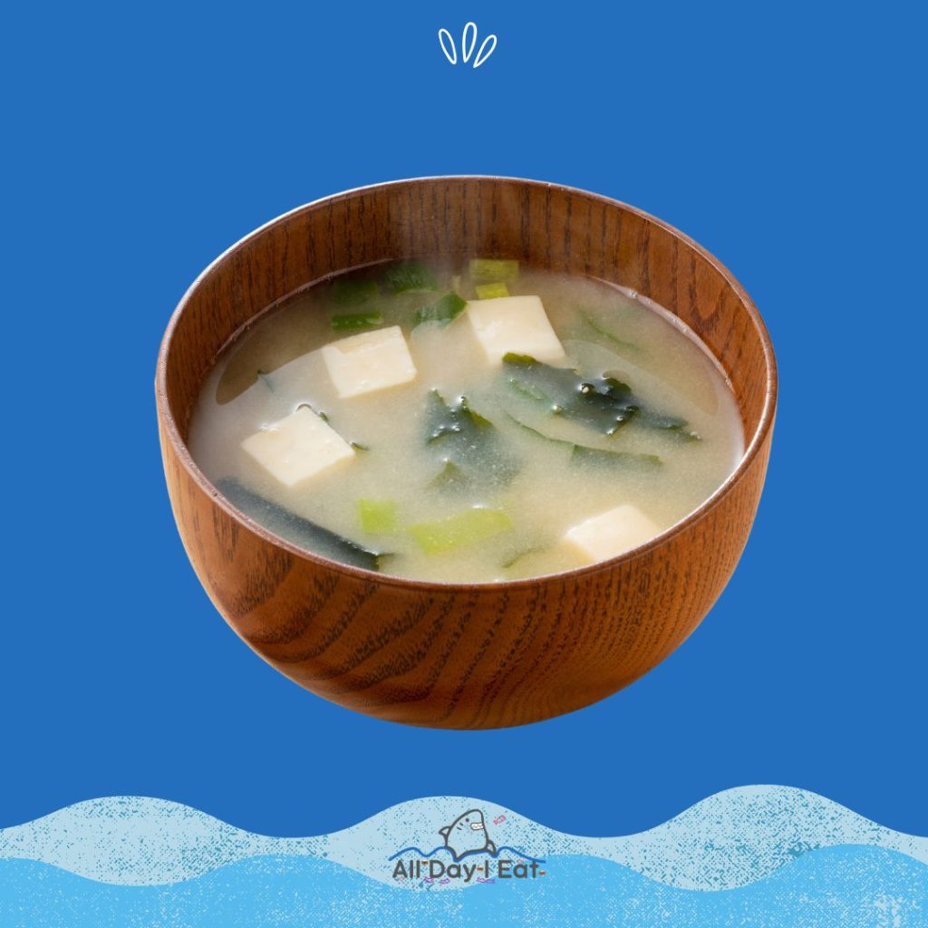 A bowl of miso soup on a blue background.