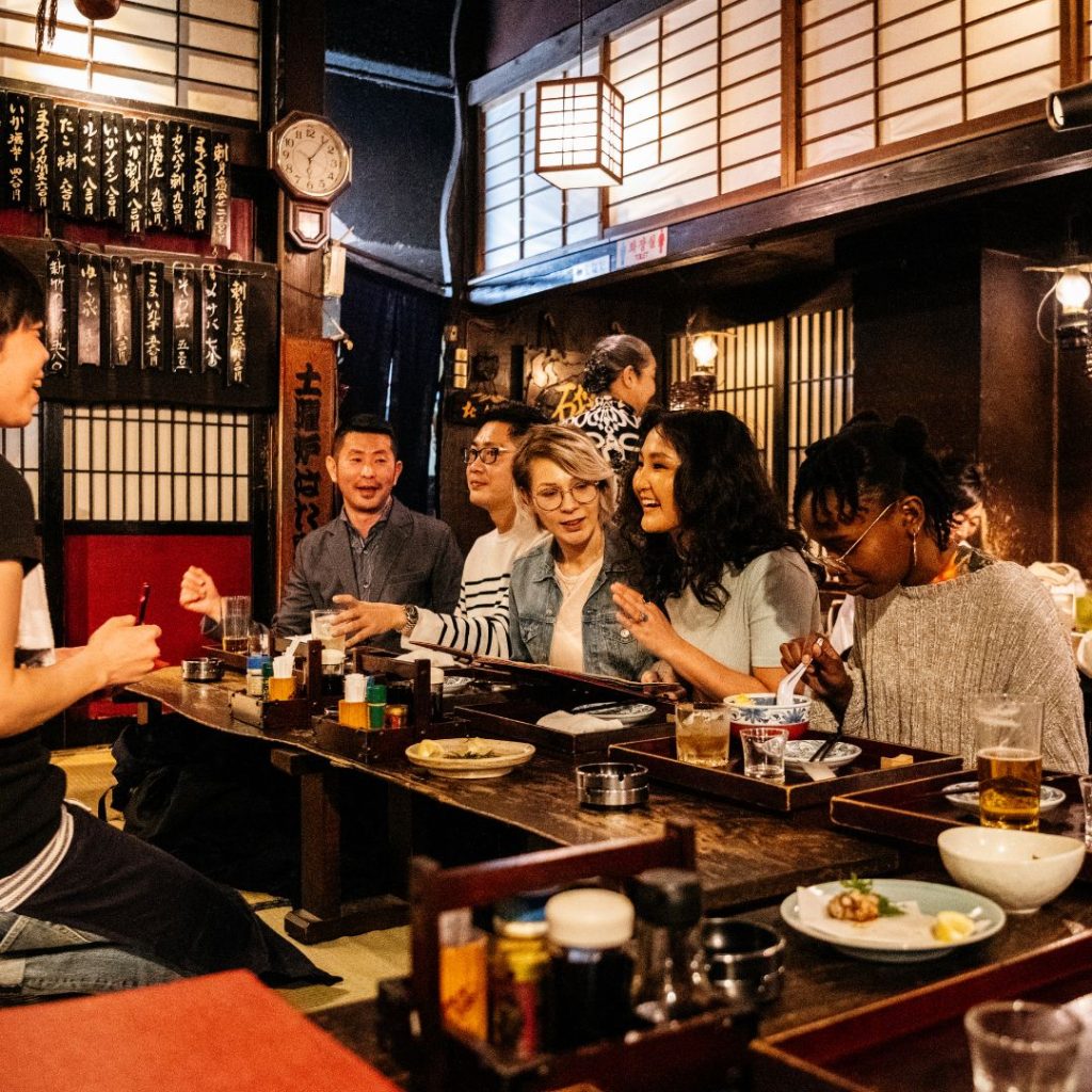 group of friends eating in izakaya