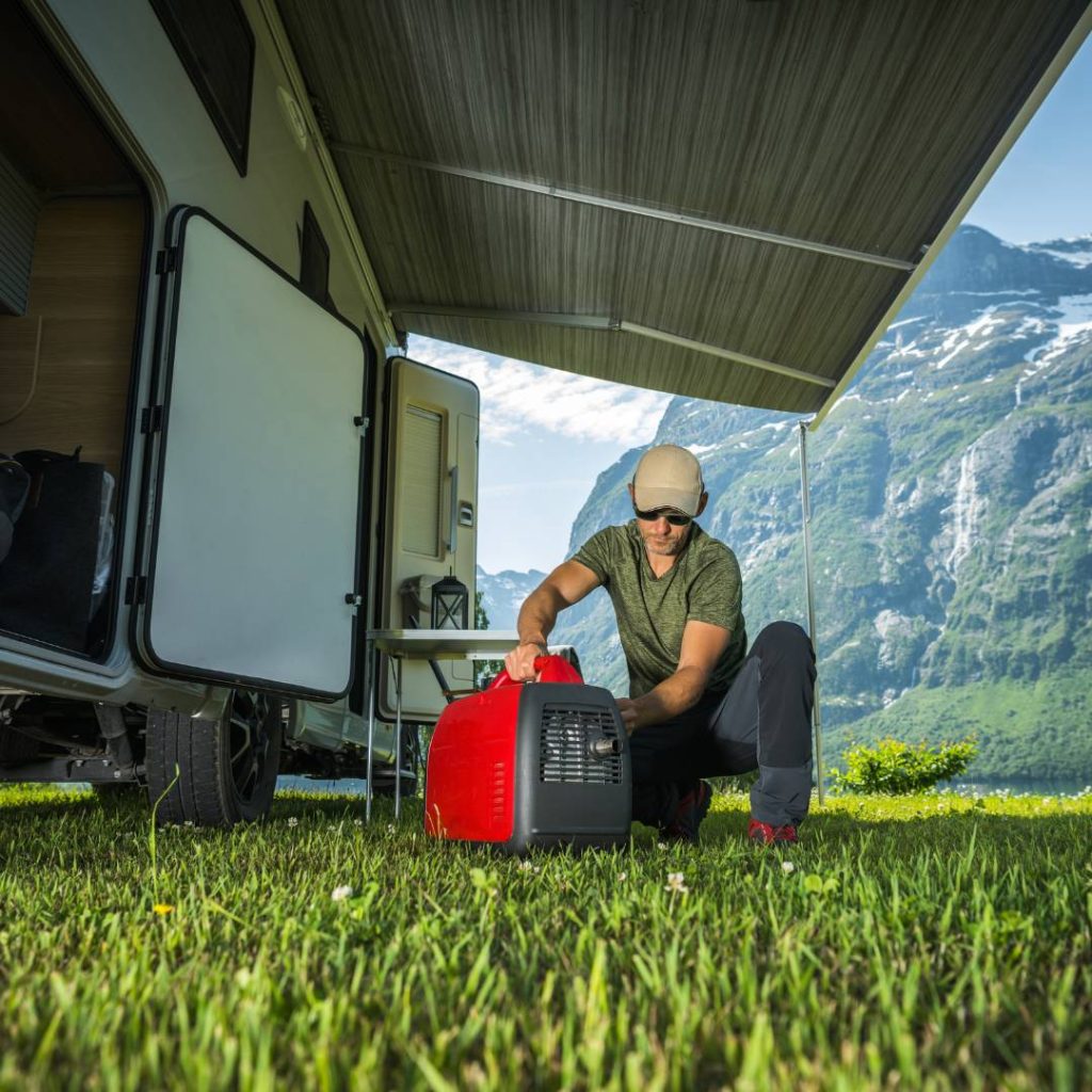 A man setting up a Jackery Explorer 1000 portable generator in front of an RV.