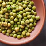 Wasabi peas in a bowl on a table.