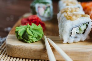 Sushi on a wooden cutting board with chopsticks.