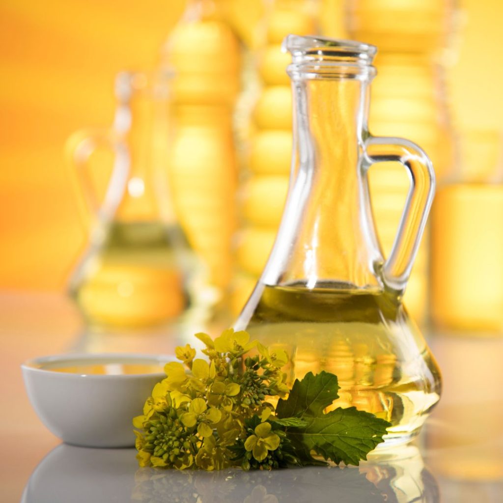 A bottle of oil rests on a white table.