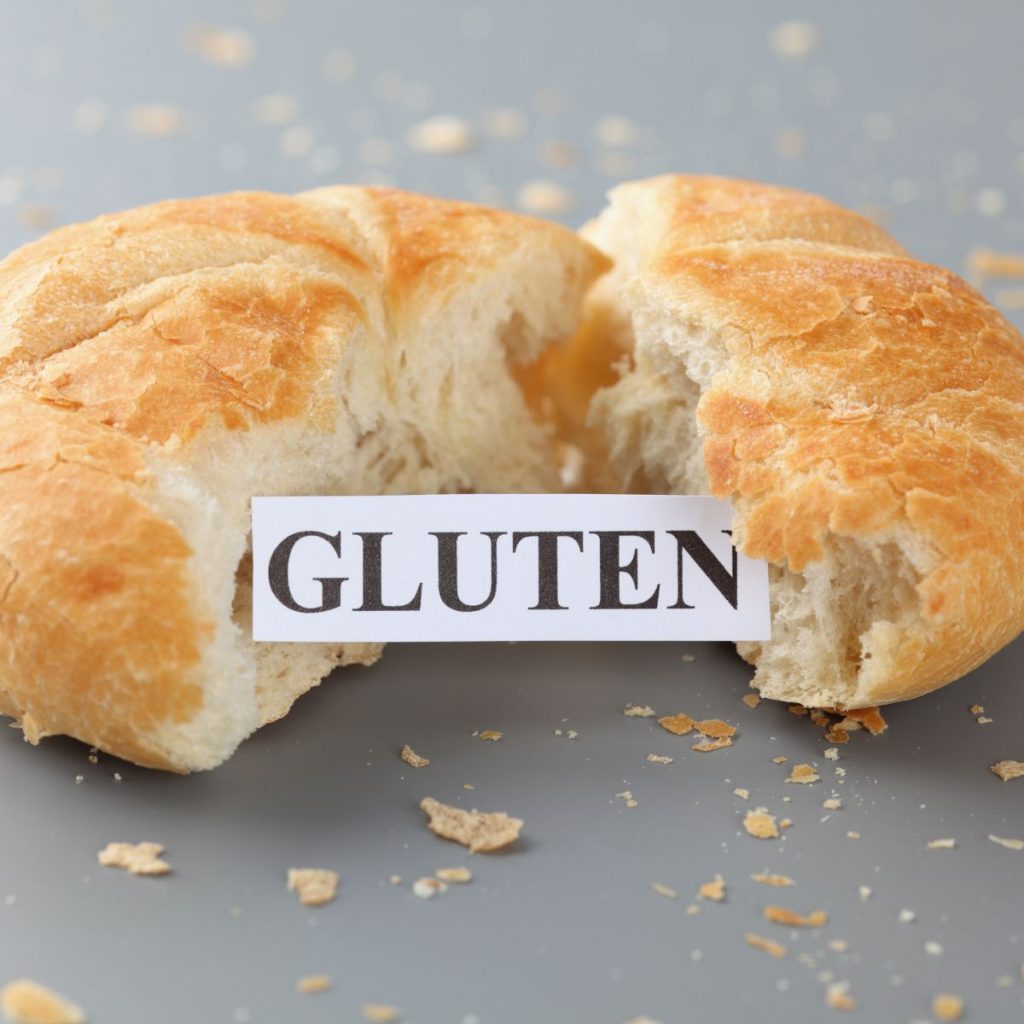 A paper labeled as "gluten" sits in between a split bread.