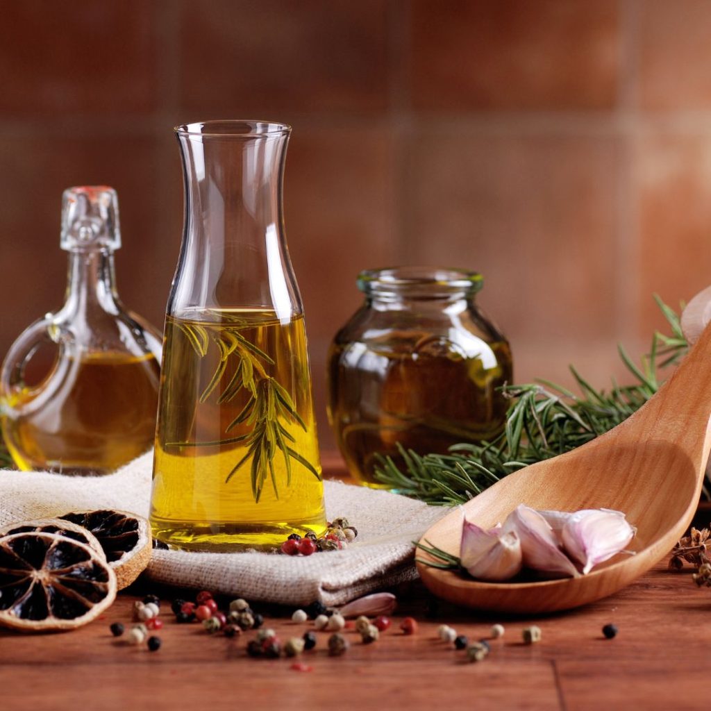 Bottles of extra virgin olive oil and vegetable oil rest on a table.