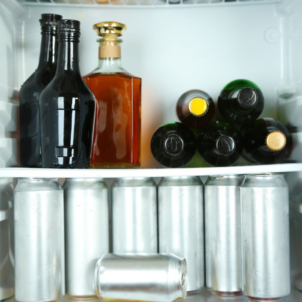 Tinted extra virgin olive oil bottles are stored in a refrigerator.