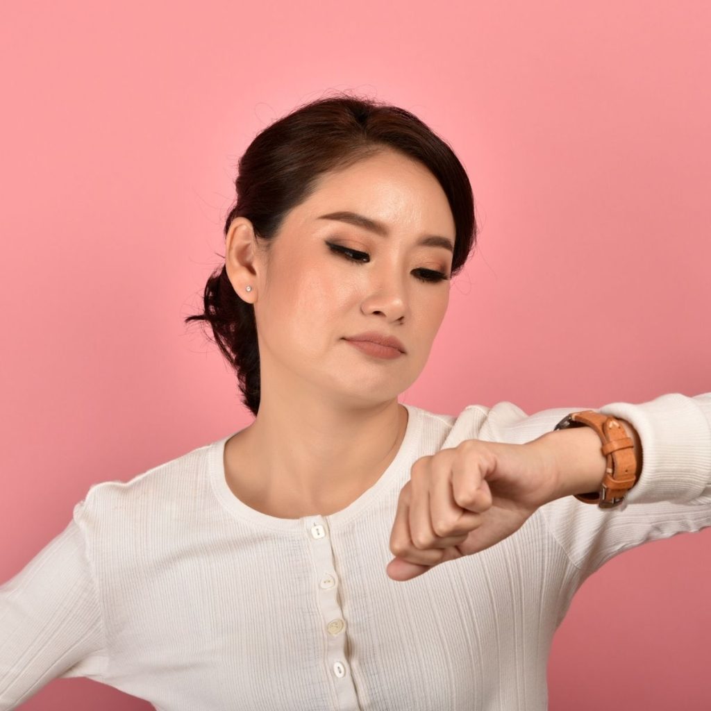 A woman looks at her watch.