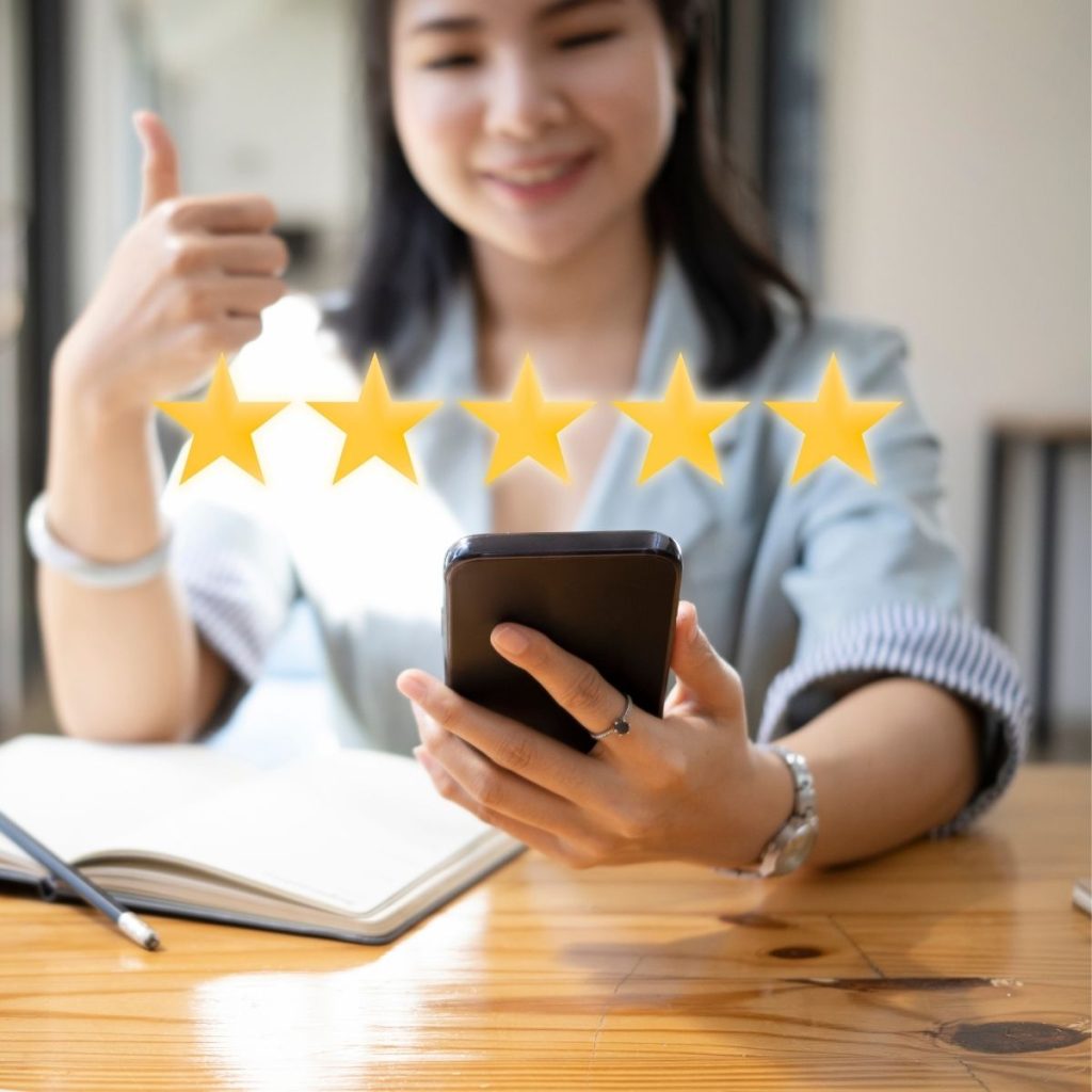 A woman raises her thumb while giving a 5-star rating to a travel property. 