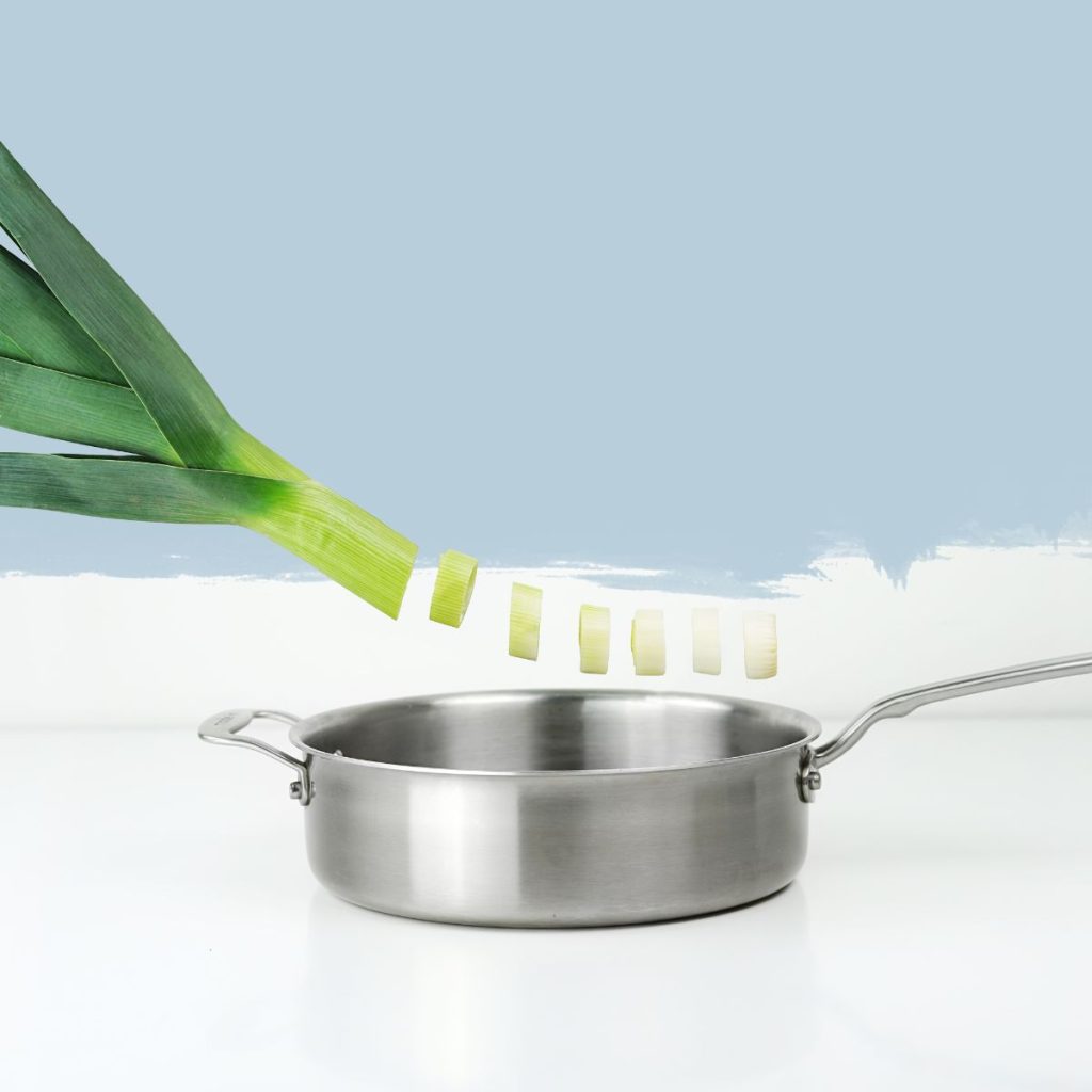 A graphic shows a chopped vegetable go into a stainless steel pan.