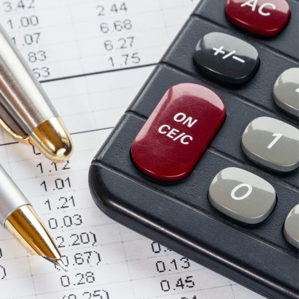 A pen and a calculator rest on a printed spreadsheet.