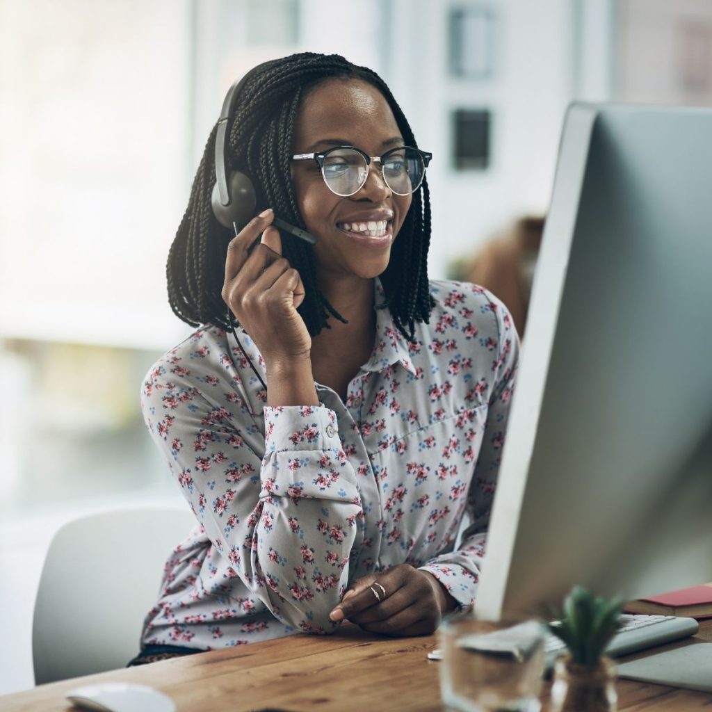 A customer service representative answers a call on her desk.