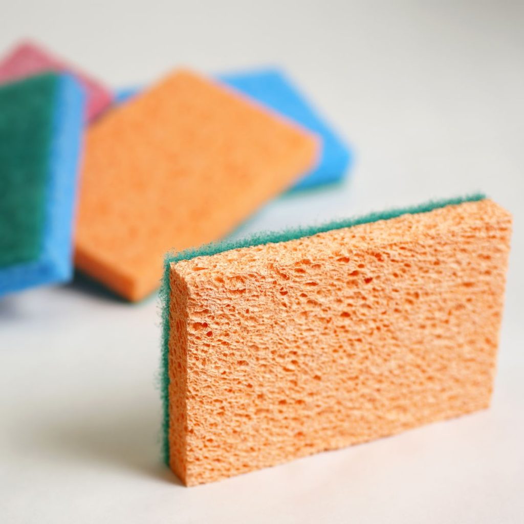 A set of abrasive cleaning sponges rest on a white surface.