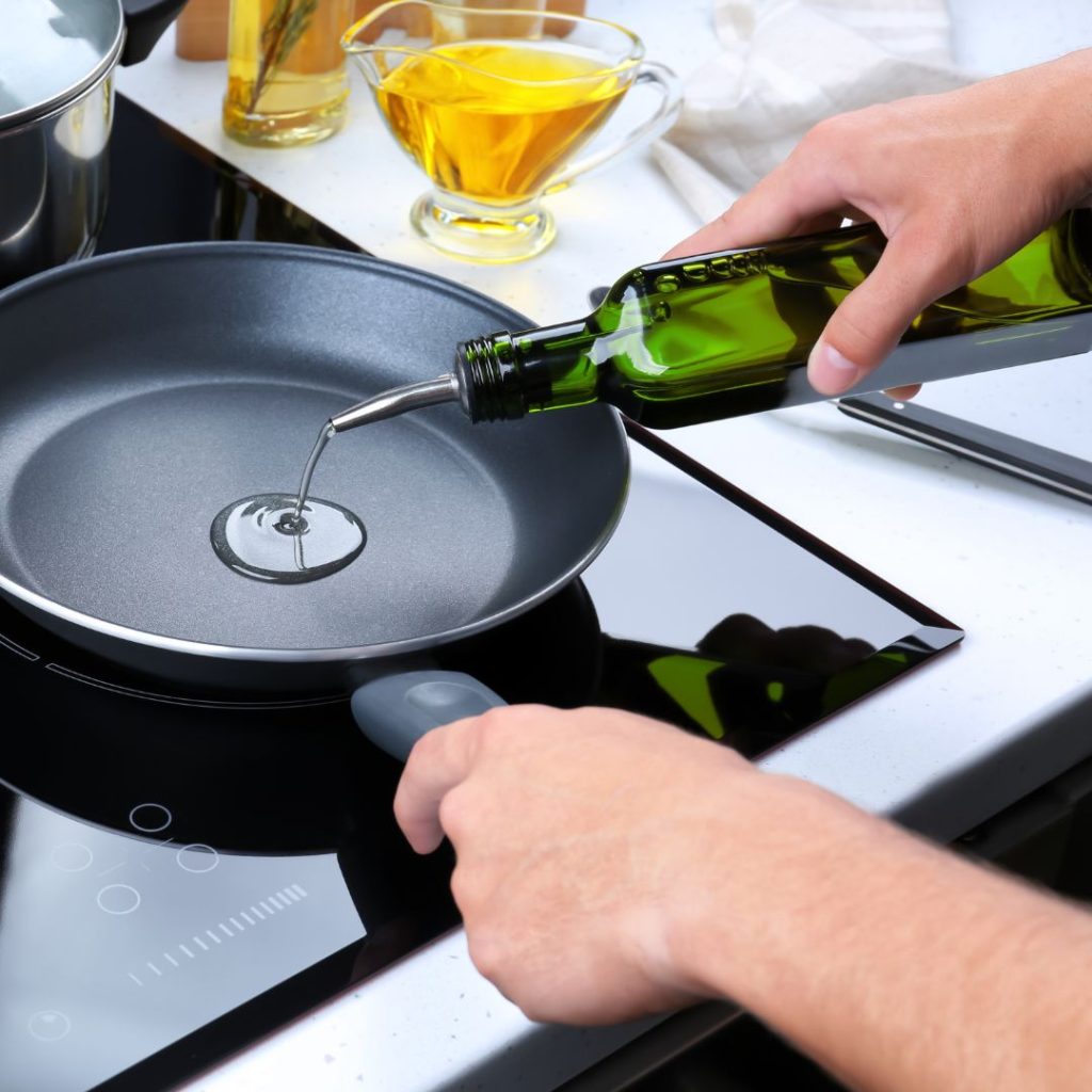 Extra virgin olive oil is poured into a cooking pan.