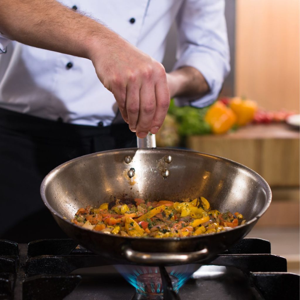 https://alldayieat.com/wp-content/uploads/2023/10/7-A-chef-sprinkles-salt-on-vegetables-being-cooked-in-a-wok-1024x1024.jpg