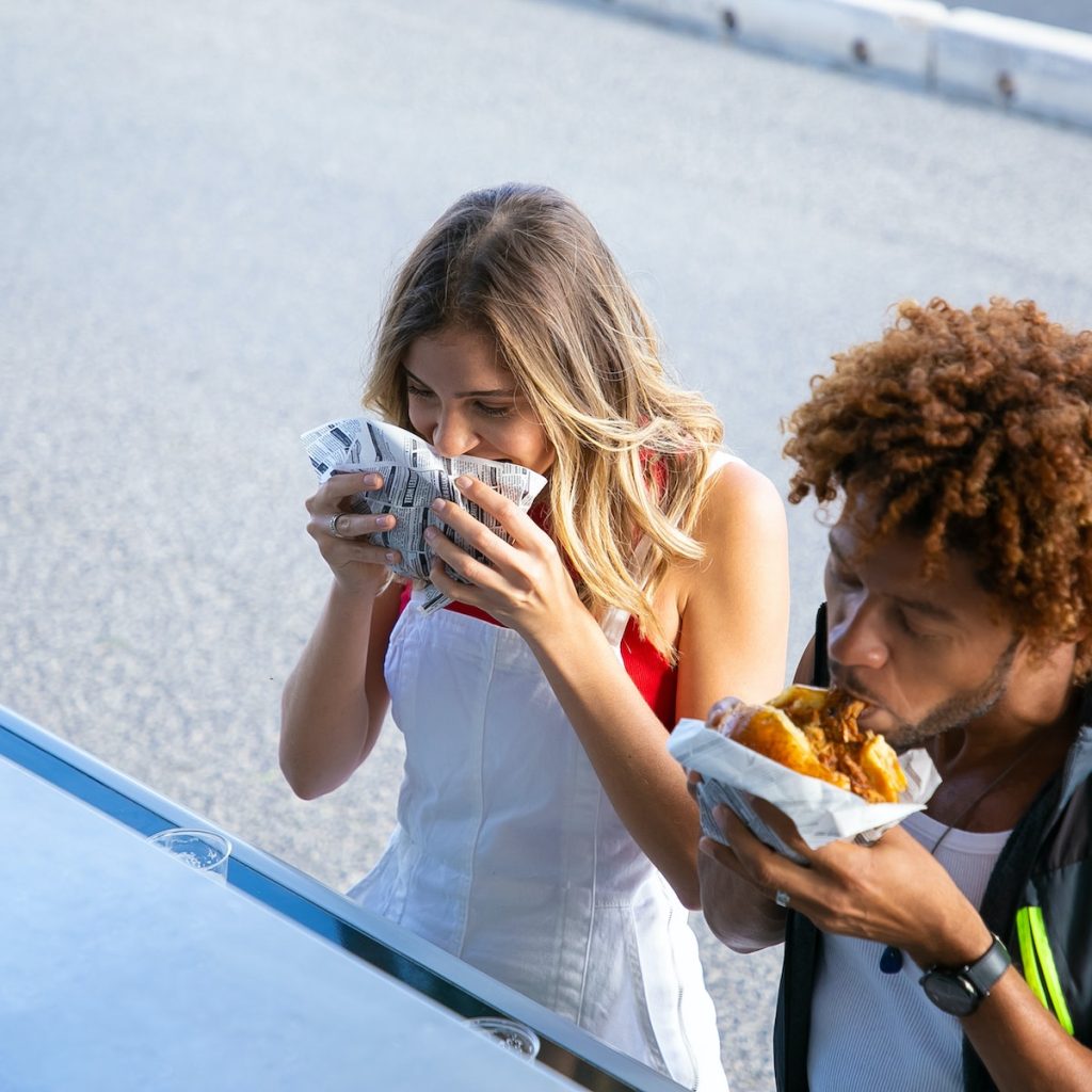 A couple eating burgers with black sesame seeds