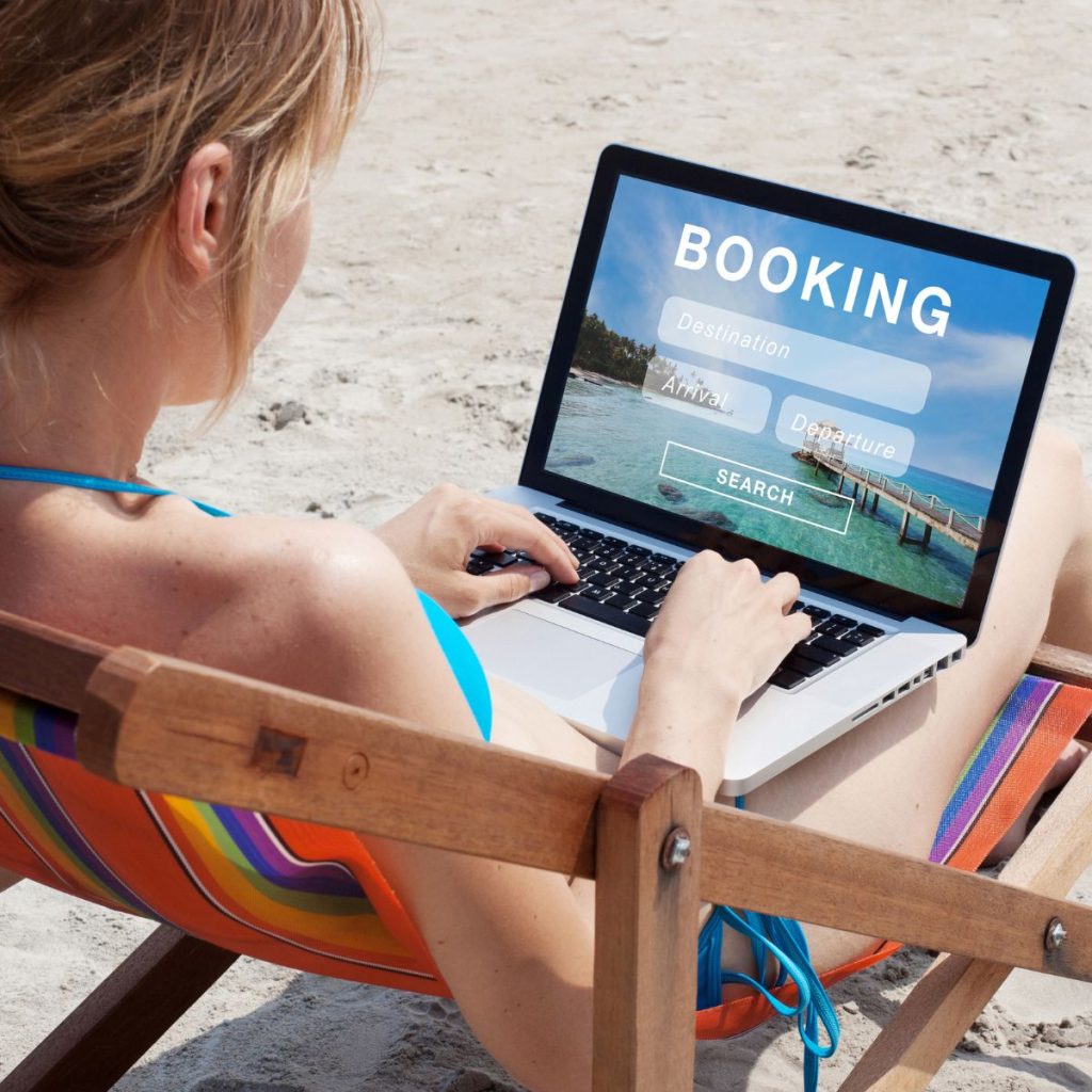 A woman at the beach booking online