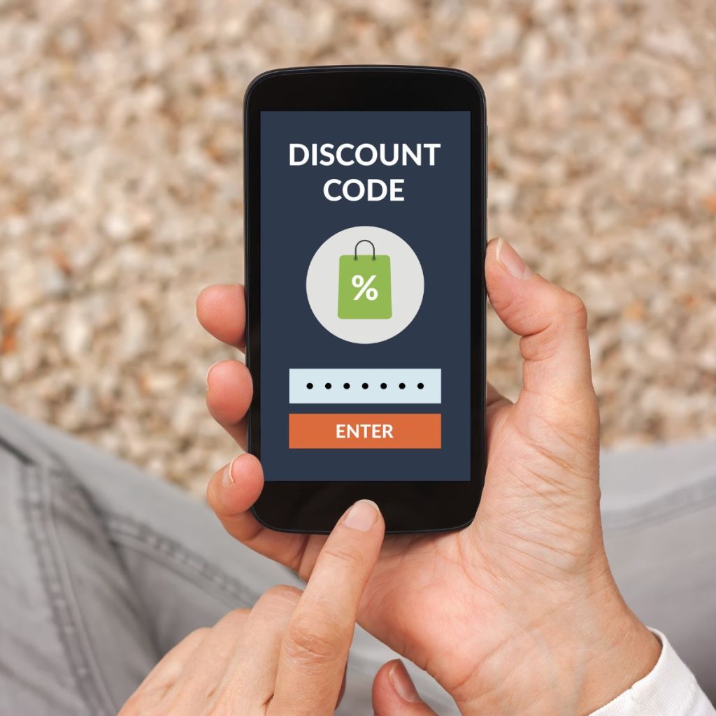 Hands holding smart phone with discount code concept on screen