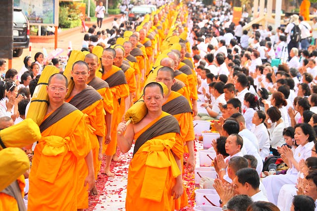 Thailand Vs Japan Travel featuring monks march in the middle of spectators