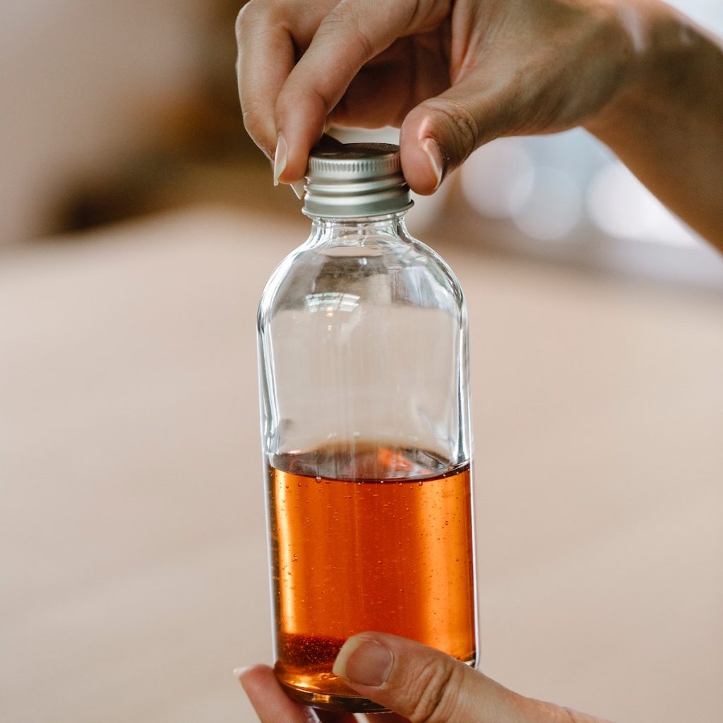 Person holding a bottle of vanilla extract