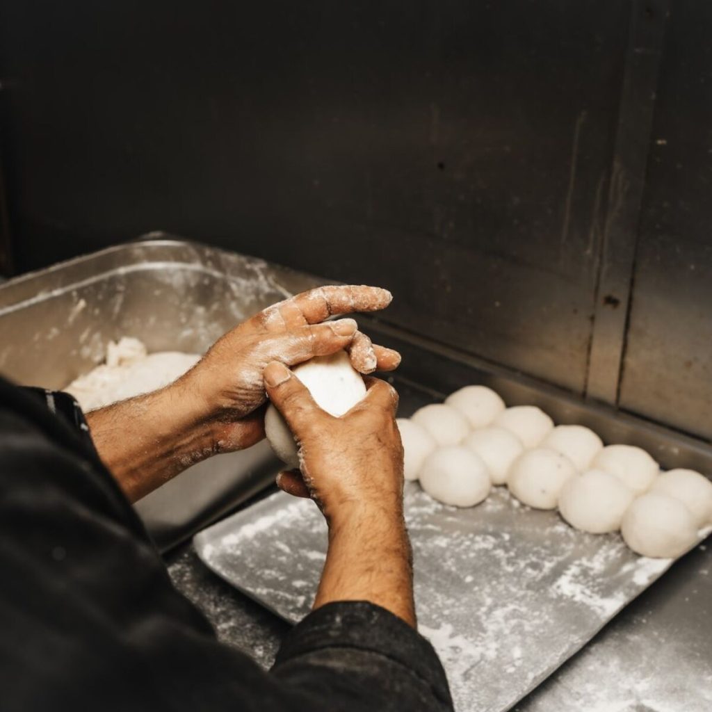 Person shaping dough into ball shapes