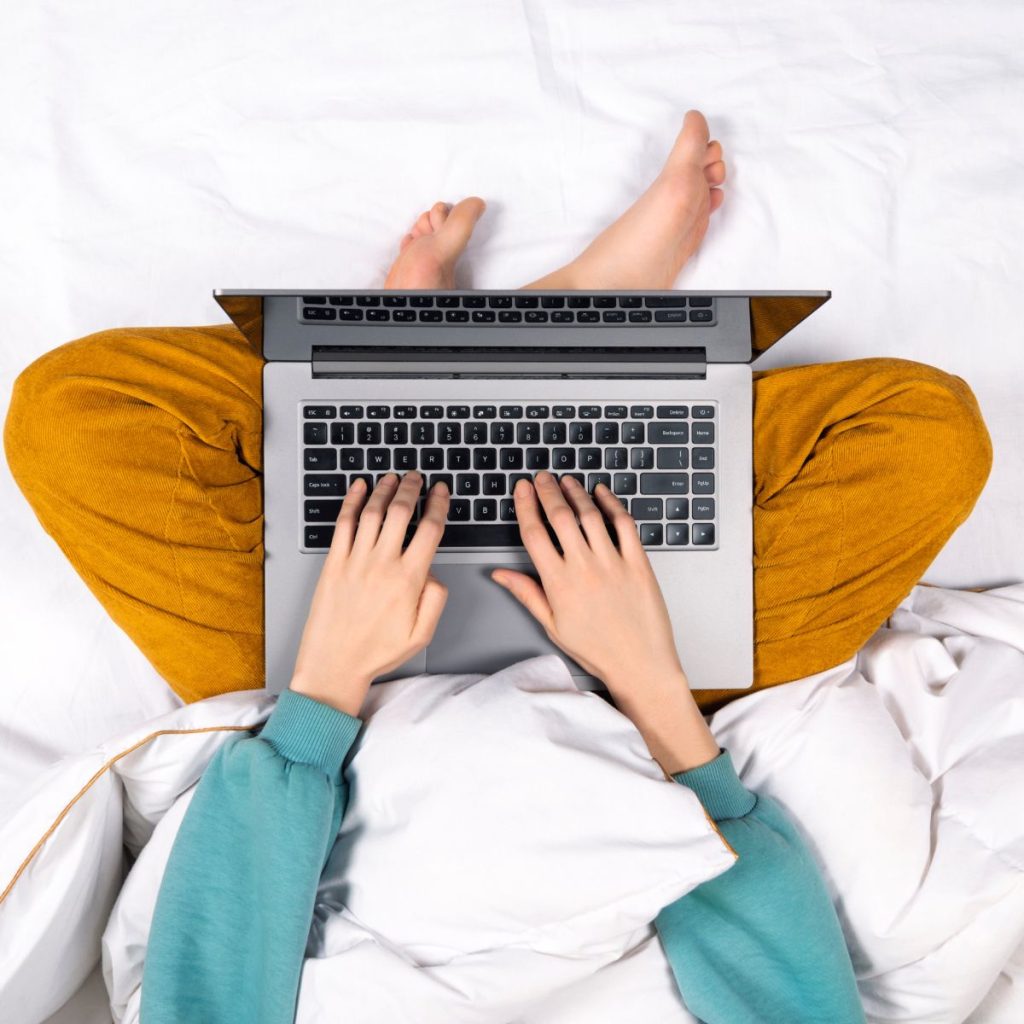 Person using a laptop on bed