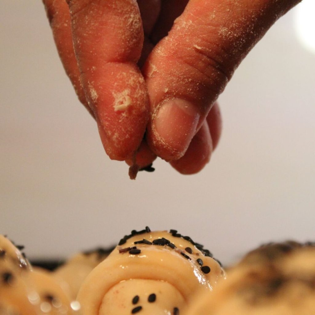 Sprinkling black sesame seeds on bread