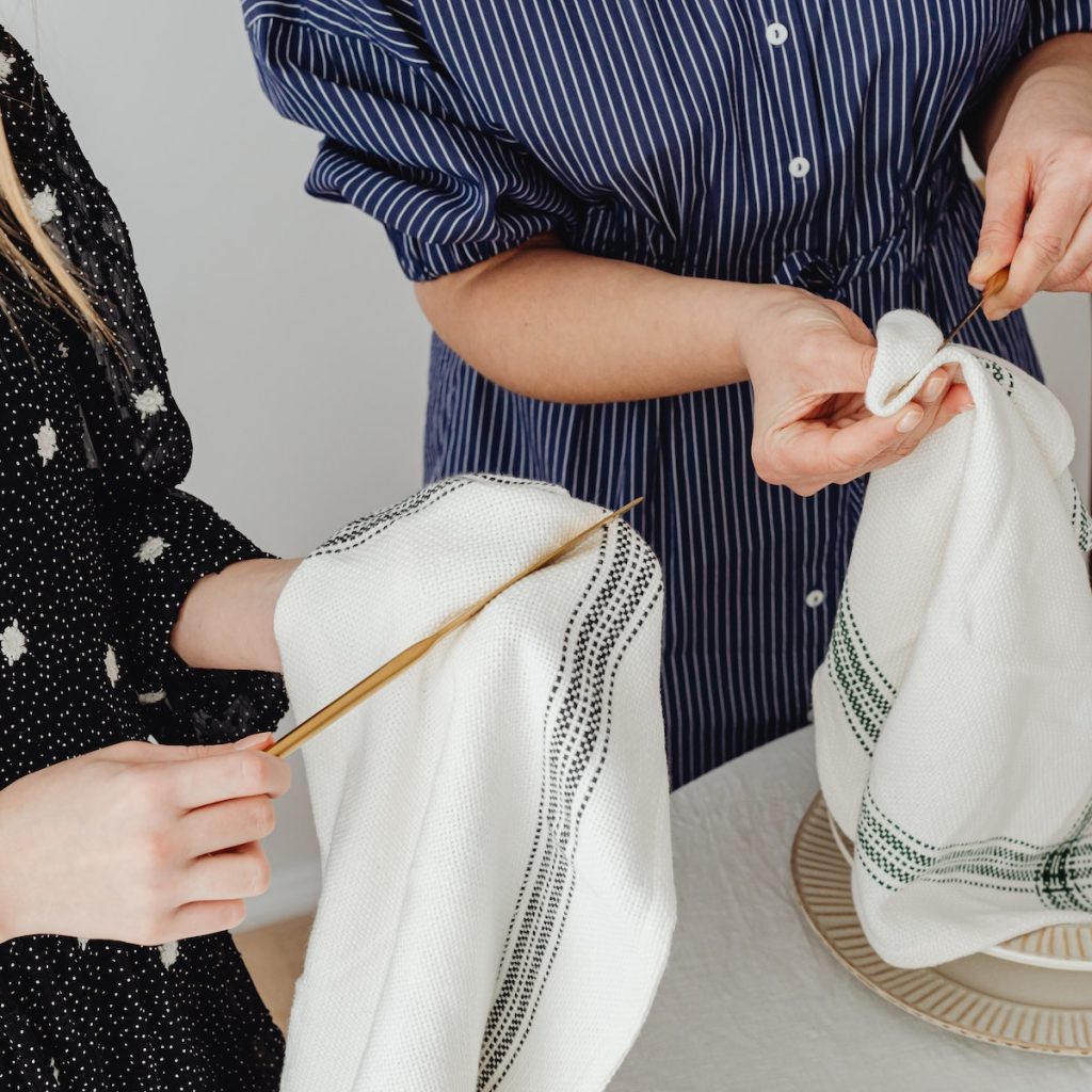 Two people wiping utensils with a clean towel