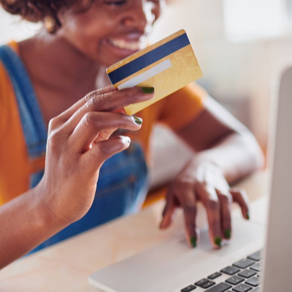 What Is Agoda Pay Later Policy - a woman booking on a laptop while holding a card