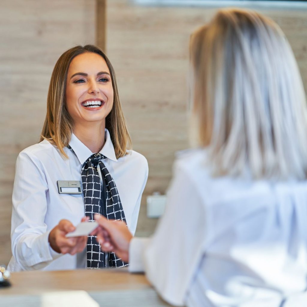 Why Is Agoda So Cheap-A hotel receptionist talking to a guest