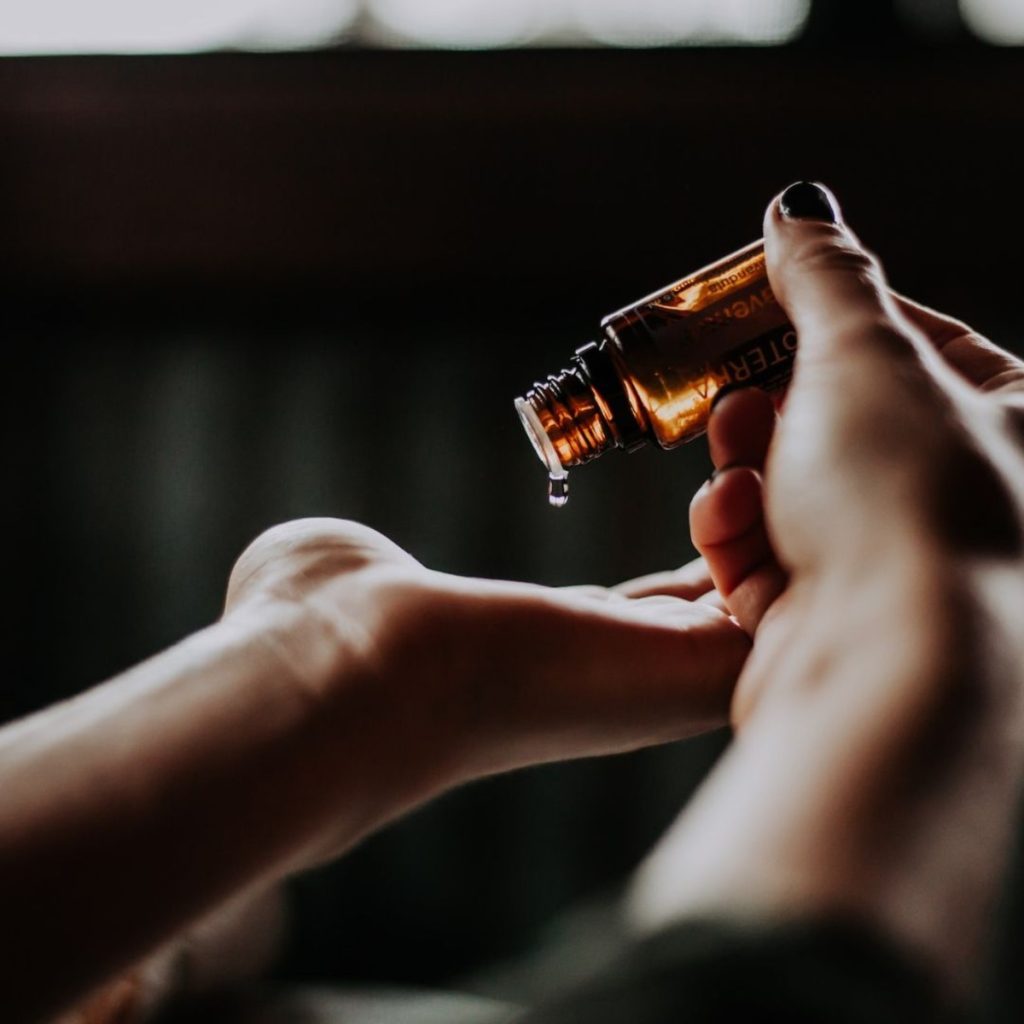 Woman pouring oil from the bottle to her hand