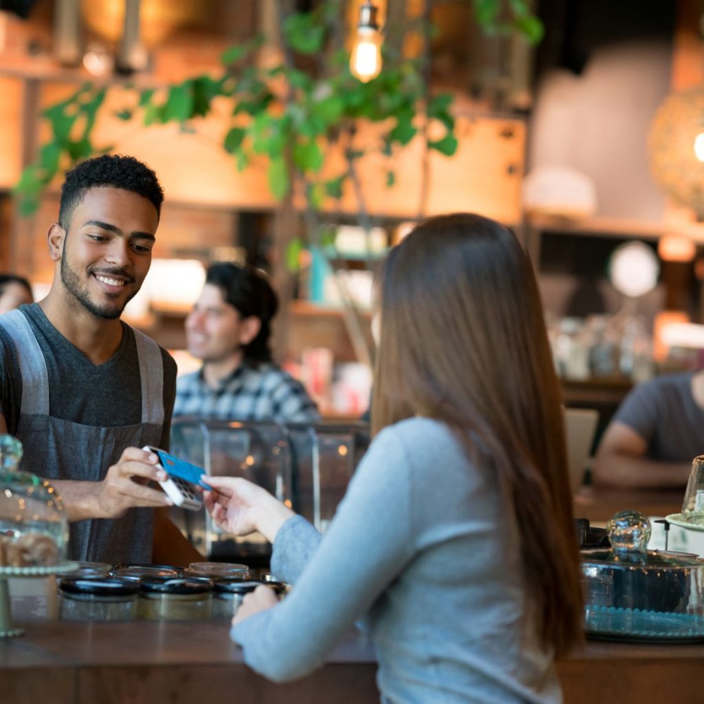 man using his credit card in restaurant