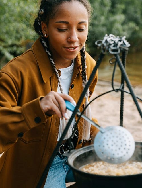 a girl cooking outdoors