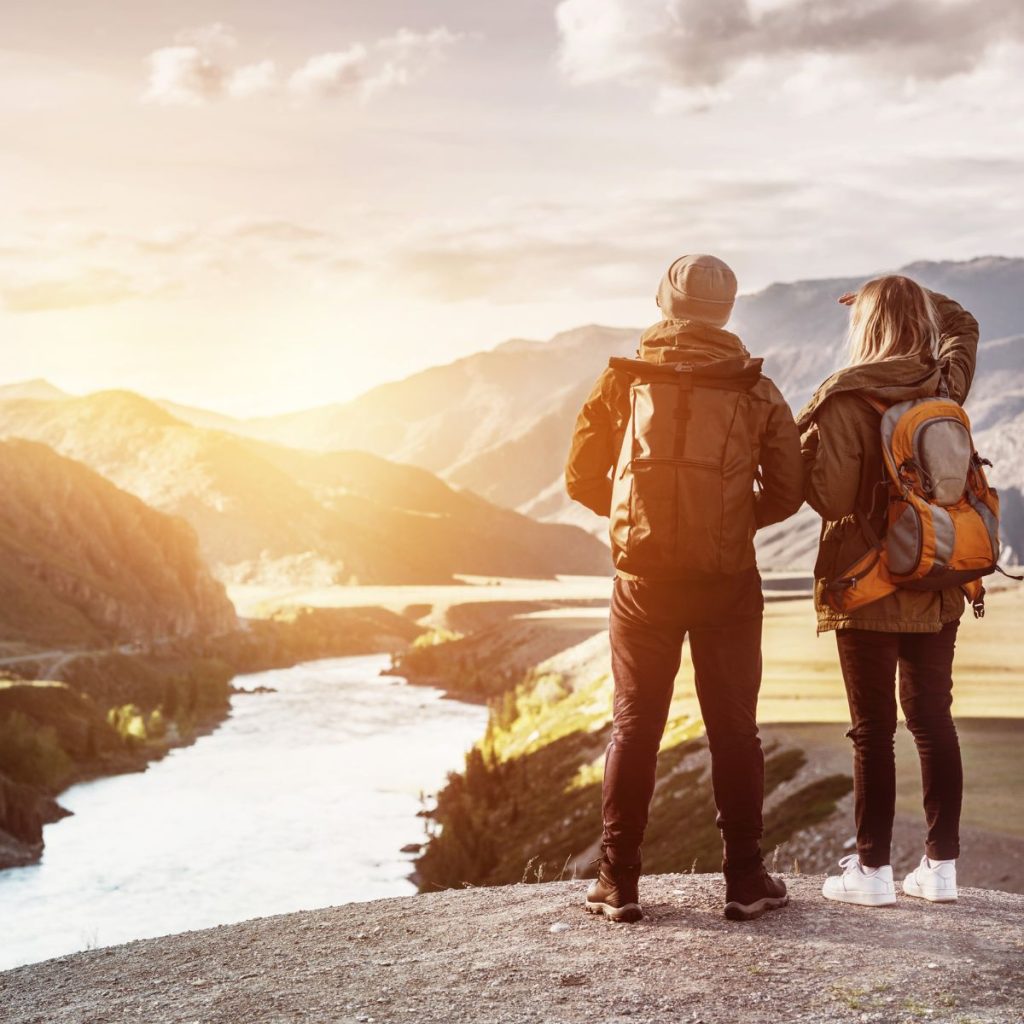 couple with their lightweight backpacks in the mountain