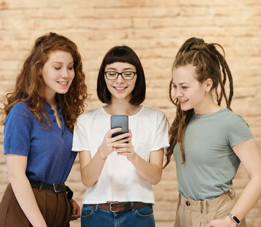 How to Use Hostelworld featuring friends browsing a phone