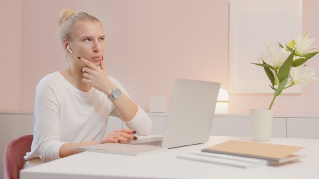 girl thinking in front of a laptop