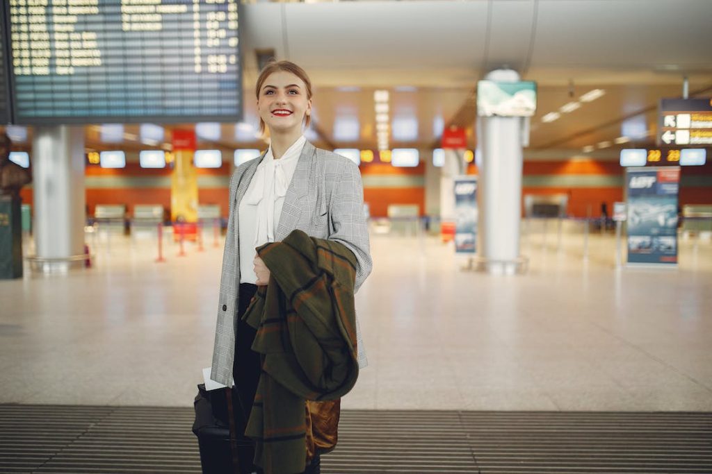 lady with jacket and suitcase inside the airport