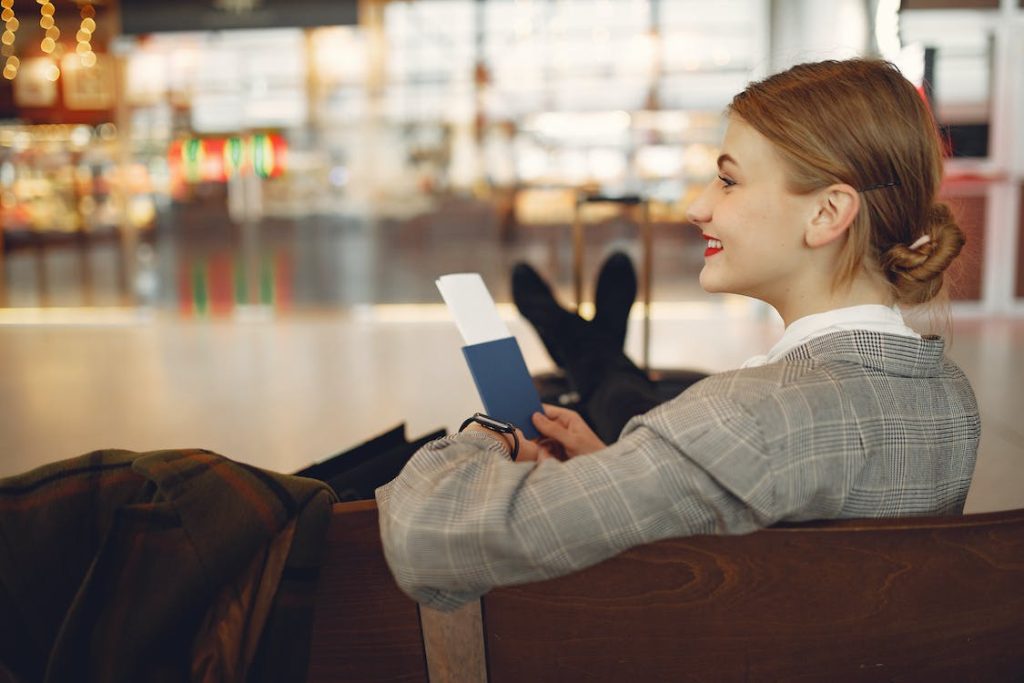 How Much Does It Cost to Fly to Japan featuring a lady waiting to board flight