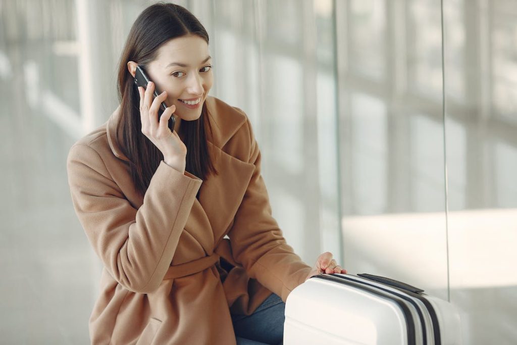 lady with a suitcase using a mobile phone