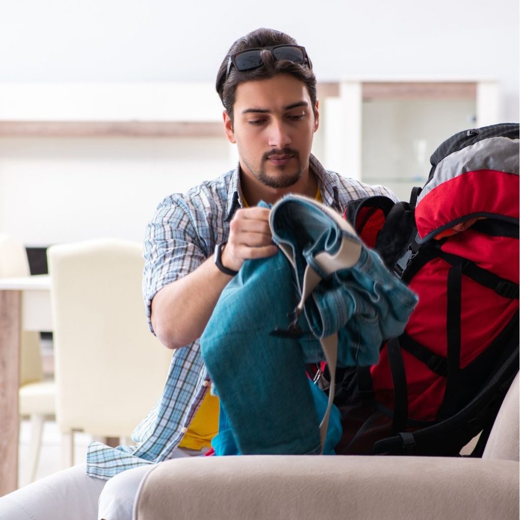 man holding his backpacking backpack