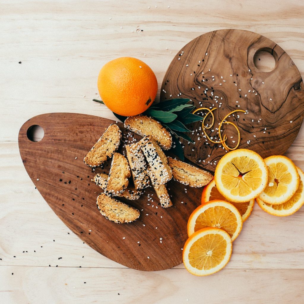 Orange slices and biscotti sprinkled with white and black sesame seeds