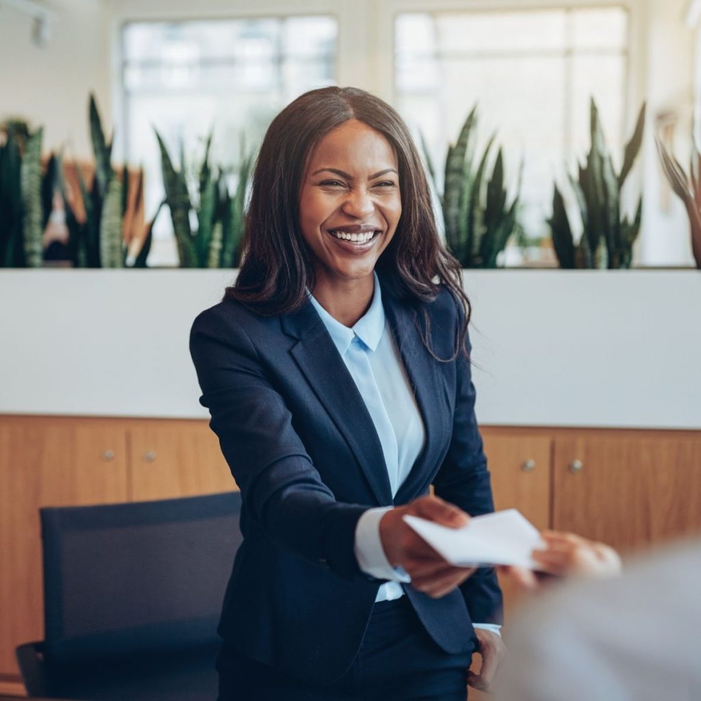 A customer representative hands a paper to a property renter.