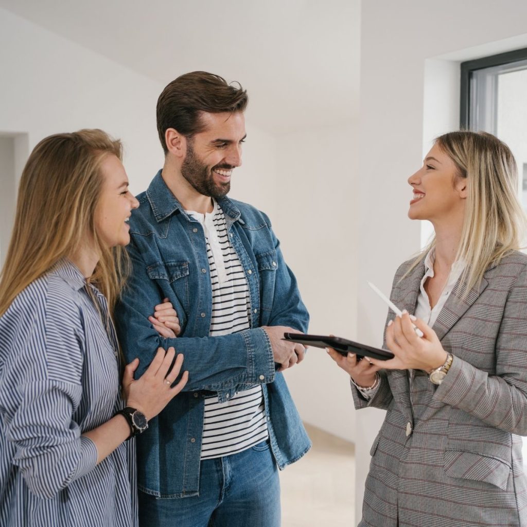 A customer service representative talks to a couple booking a place at a hotel.