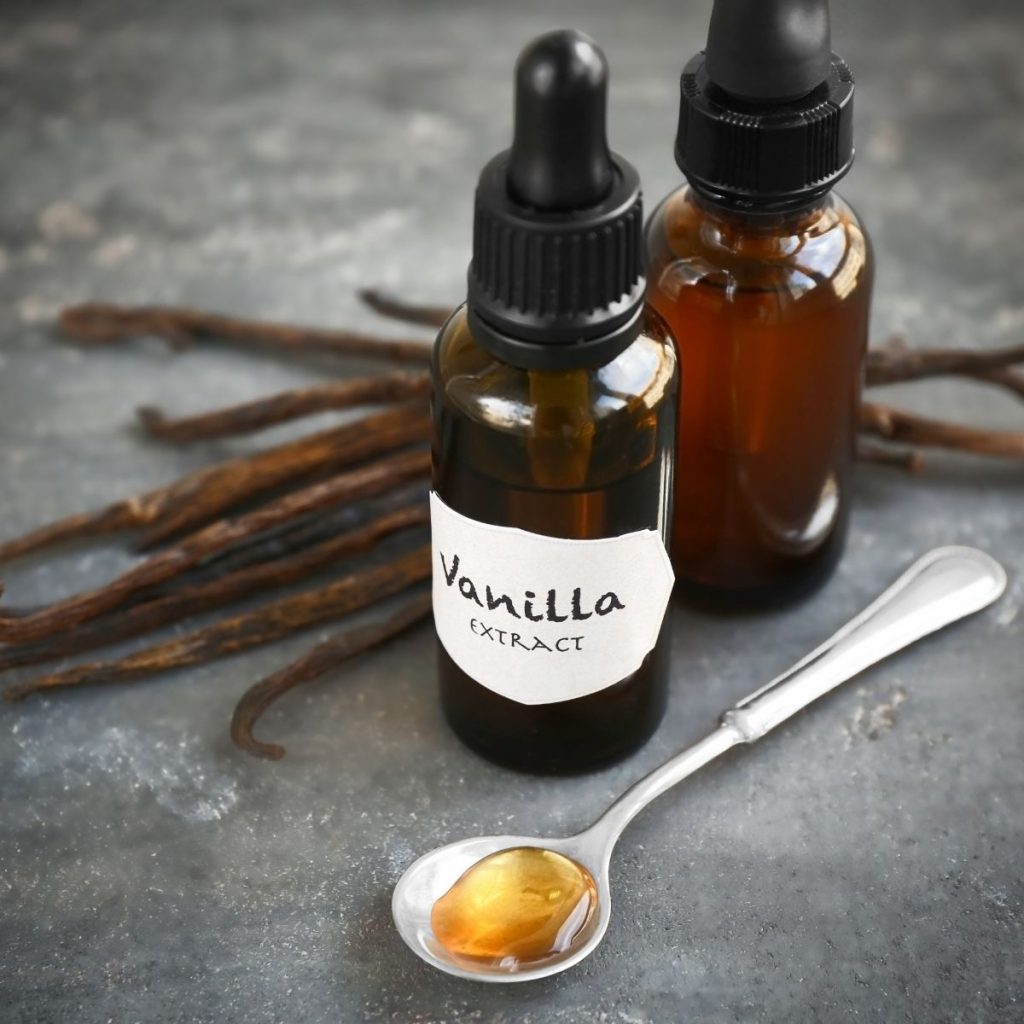 Bottles and Spoon of Vanilla Extract with Dried Beans