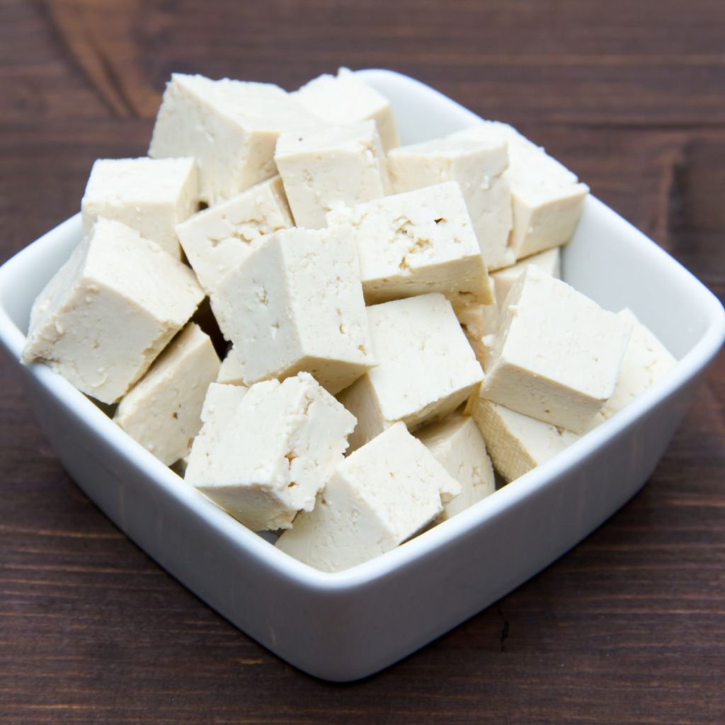 Cubes of tofu square bowl on wood