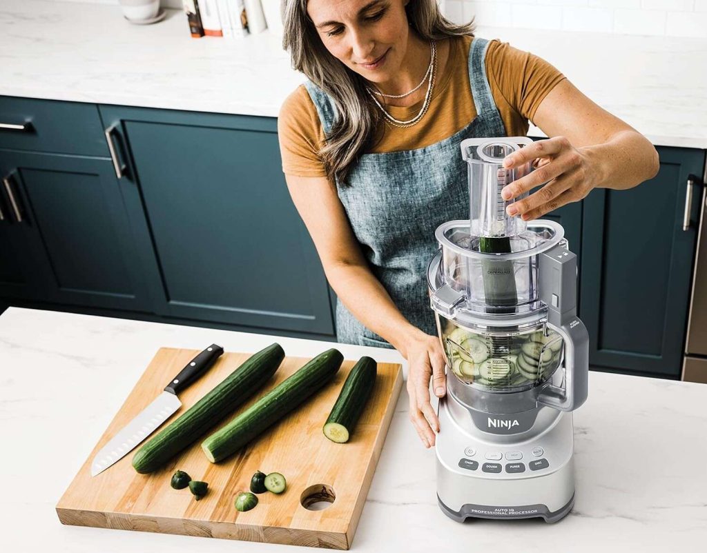 A woman using the Ninja Professional XL Food Processor 