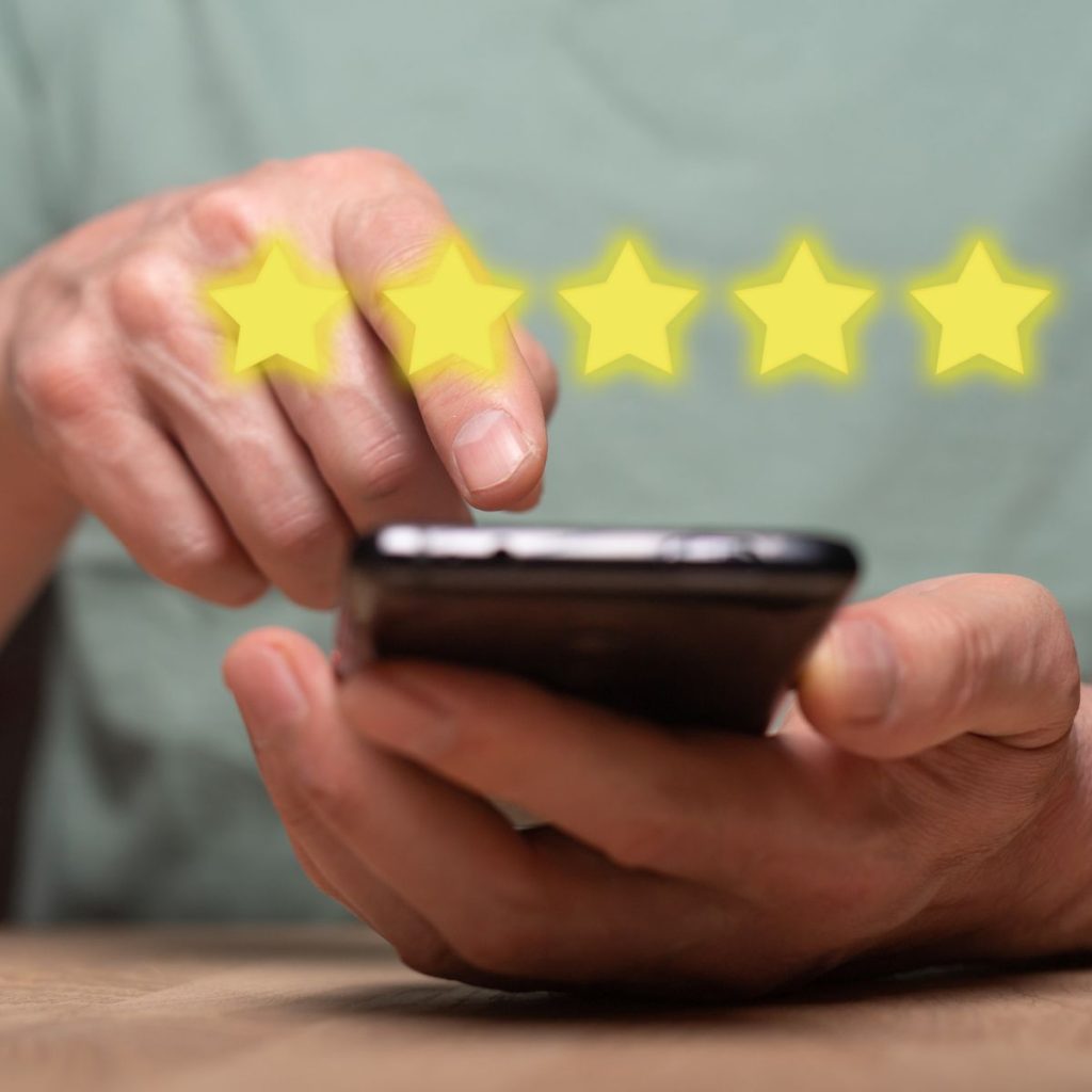 Person using a smartphone with floating 5 star rating