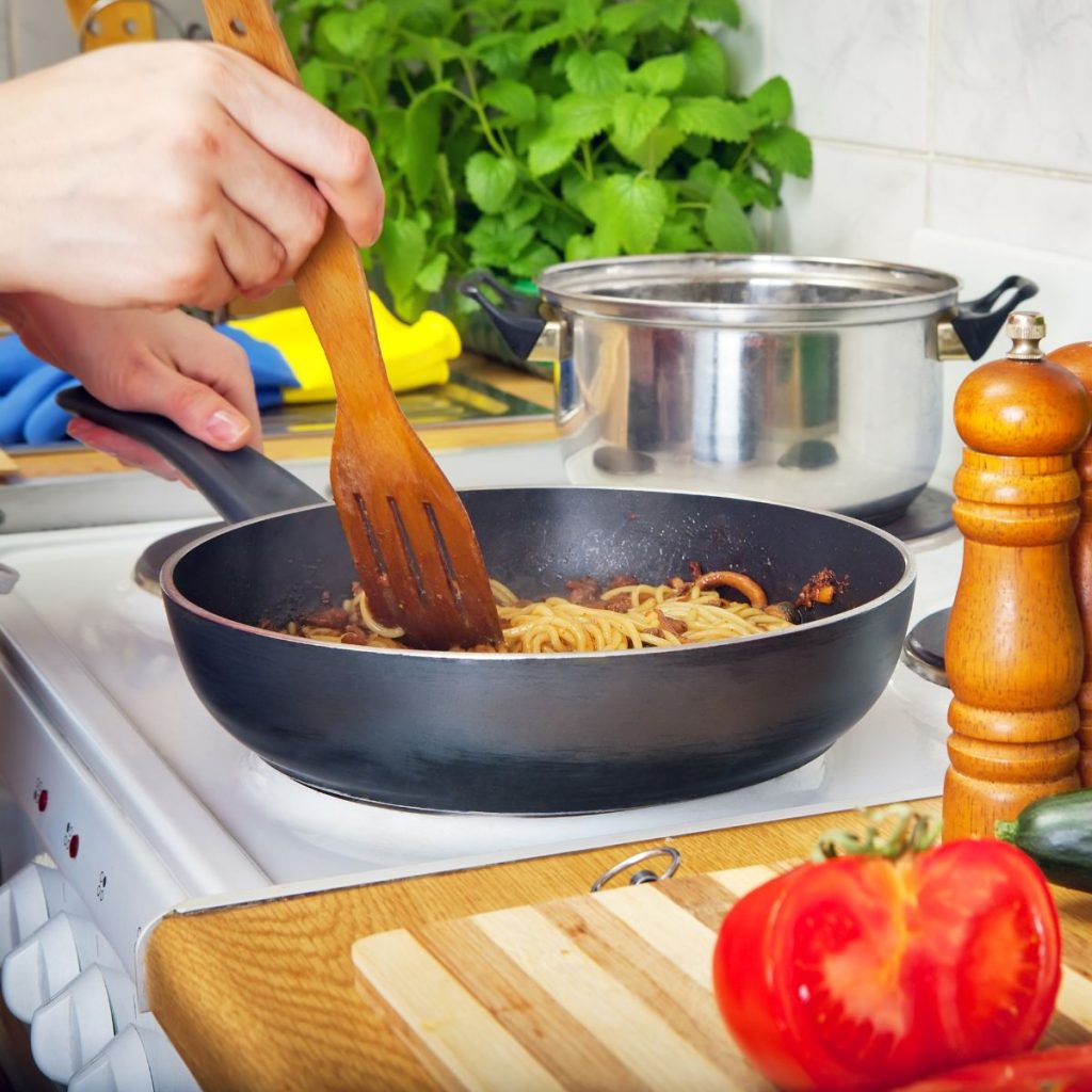 Person using a wooden utensil for cooking