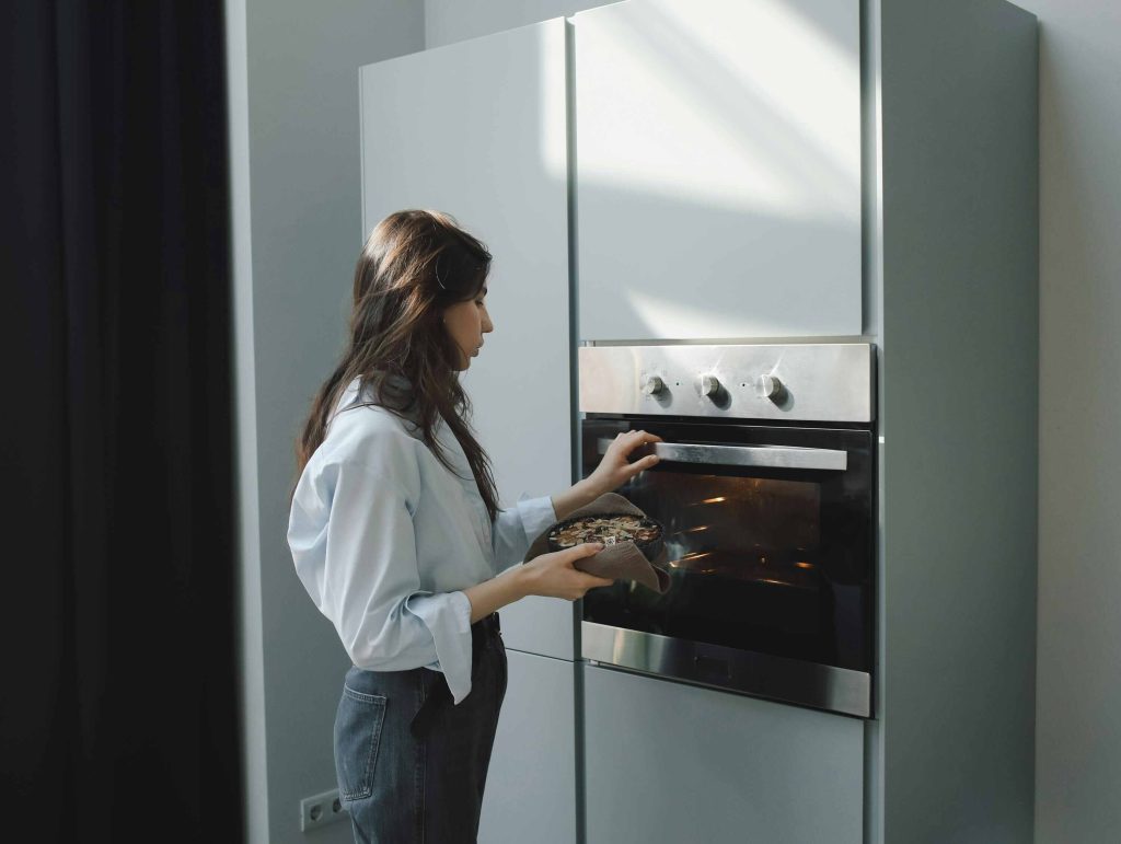 Woman cooking food using an oven