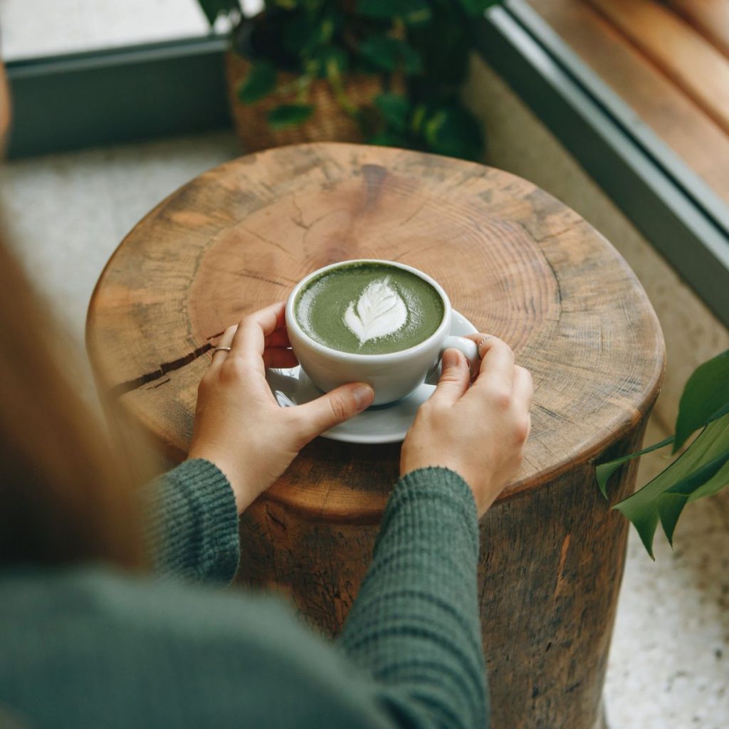 Woman holding a cup of matcha latte