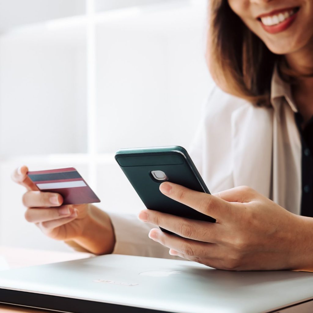 Woman holding a smartphone and a credit card